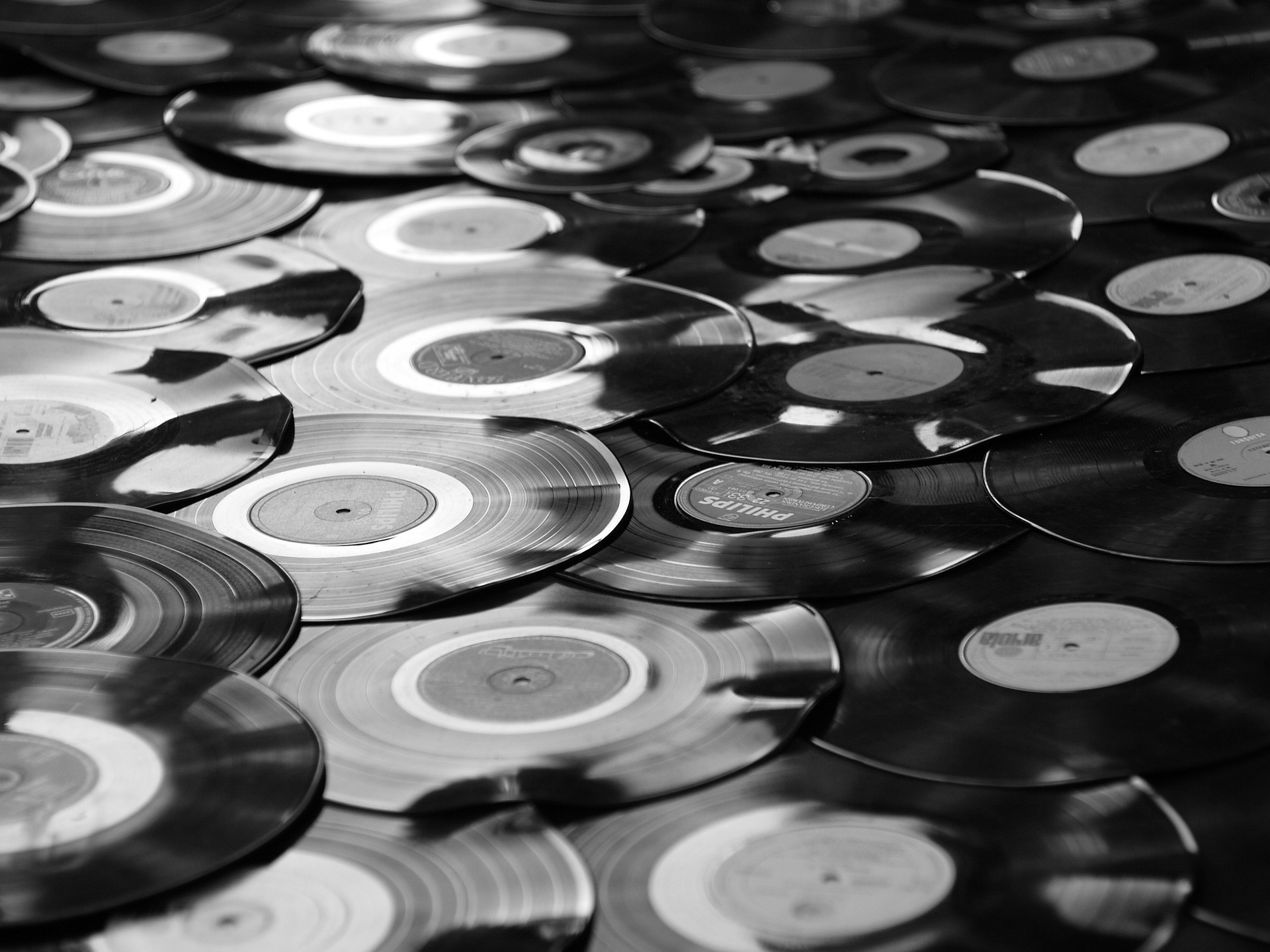 Black-and-white photo of an undending stack of vinyl records spread out one across another.